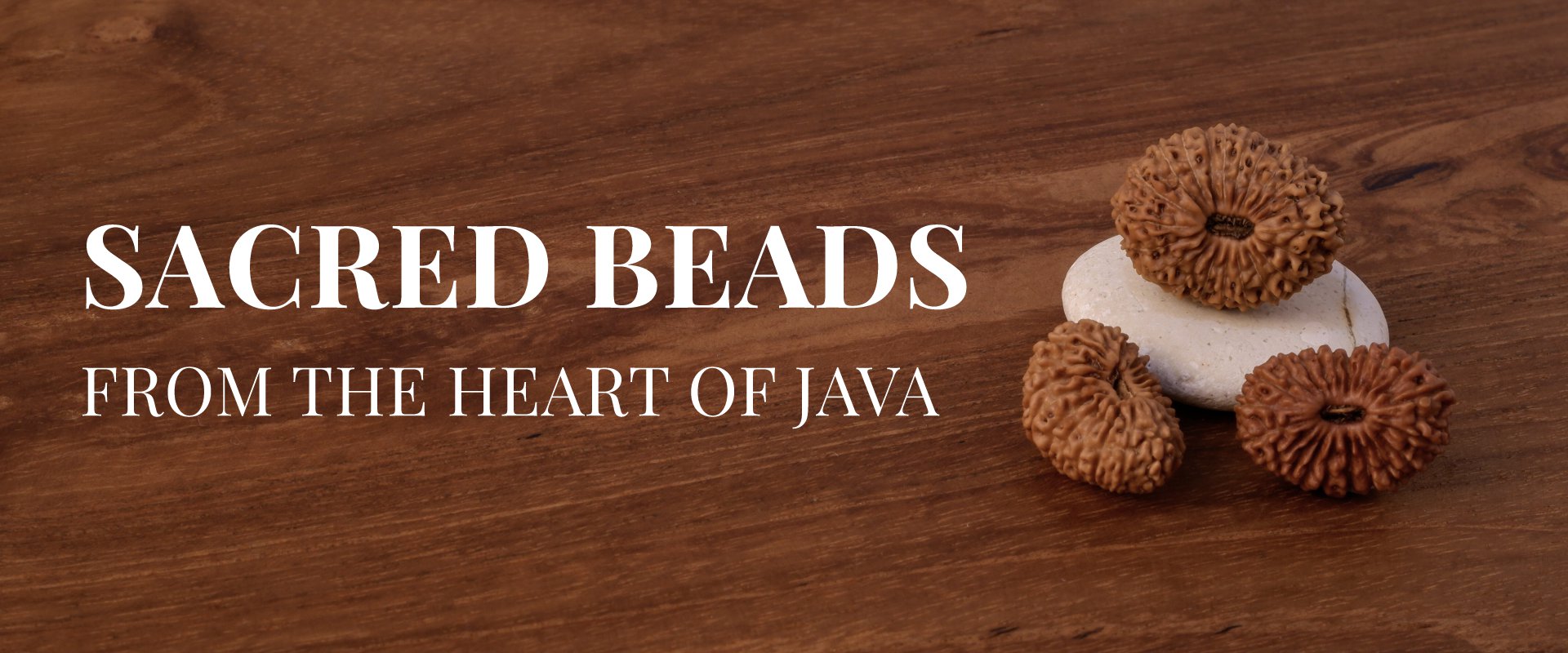 Authentic Java Rudraksha beads resting on sacred white stone, with wood background — JavaRudraksha homepage banner